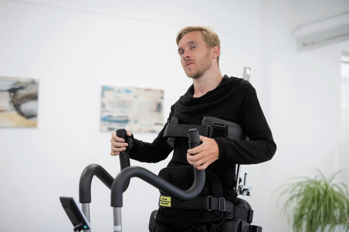 Adult actively using the arm movement handles in the Innowalk